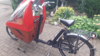 Bakfiets short cargo bike with red rain tent, and heron artwork